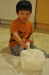 Samuel playing with snow indoors